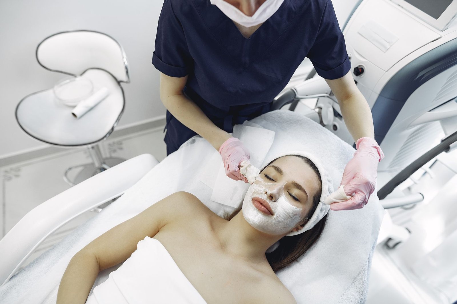 Profesional de la estética aplicando un tratamiento facial con precisión en una clínica moderna